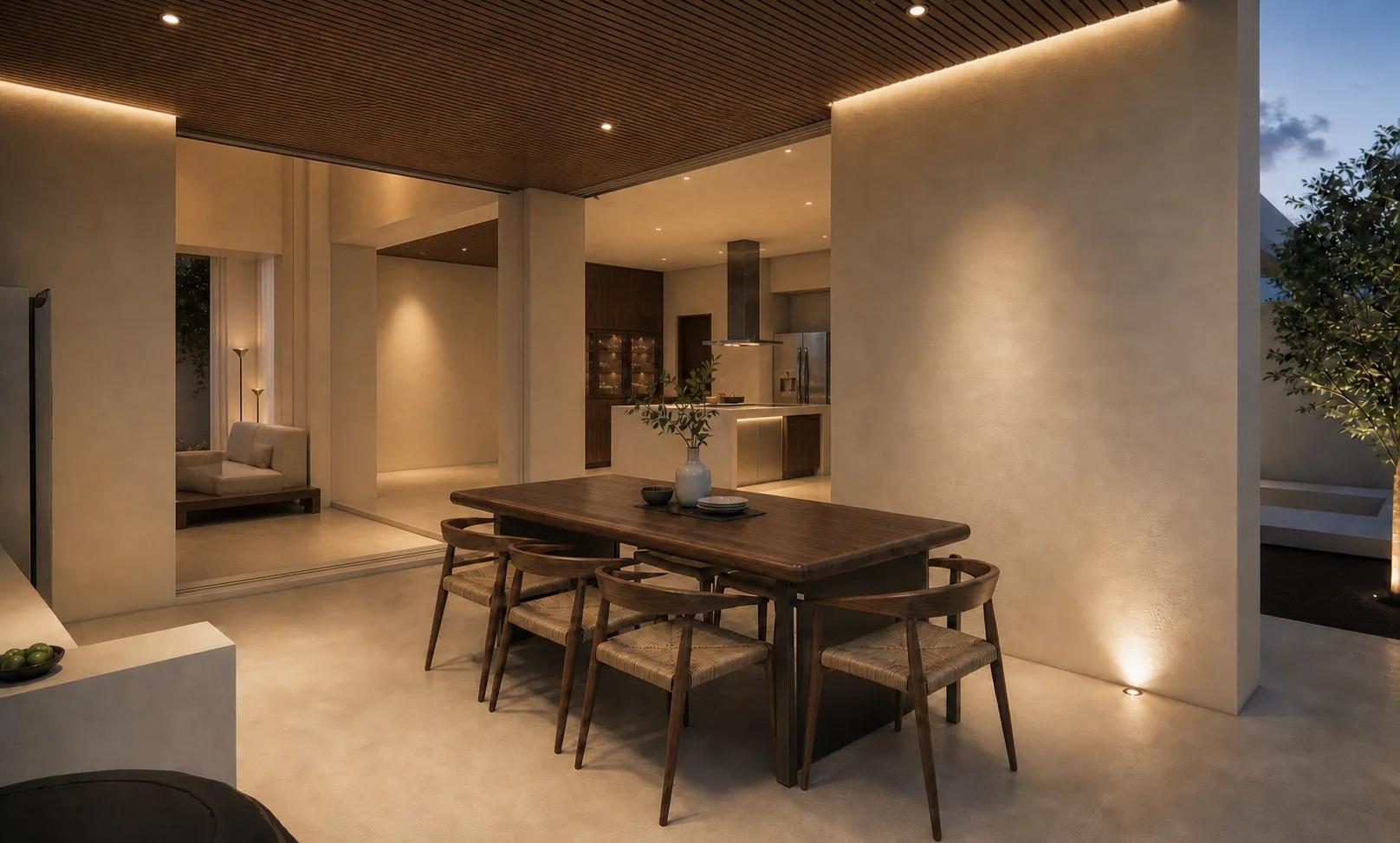 Comedor y cocina de Casa Campestre por la noche, abiertos a la terraza con iluminación cálida